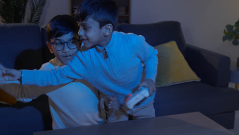 Dos-Niños-Pequeños-En-Casa-Peleando-Por-Los-Controladores-Jugando-En-La-Consola-De-Juegos-De-Computadora-En-La-Televisión-A-Altas-Horas-De-La-Noche-2